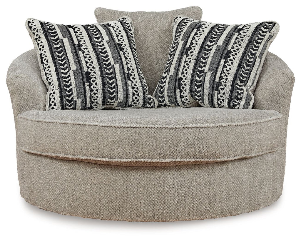 Light beige oversized accent chair with striped geometric throw pillows and round swivel seat