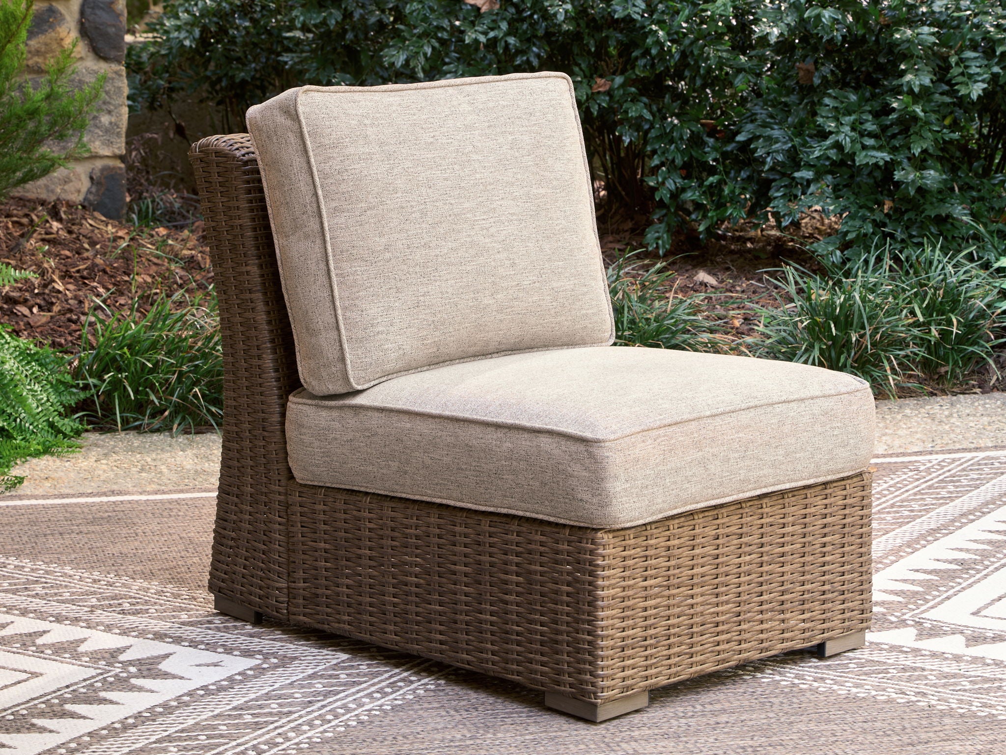Beige armless chair with cushion and woven wicker frame, tall square backrest