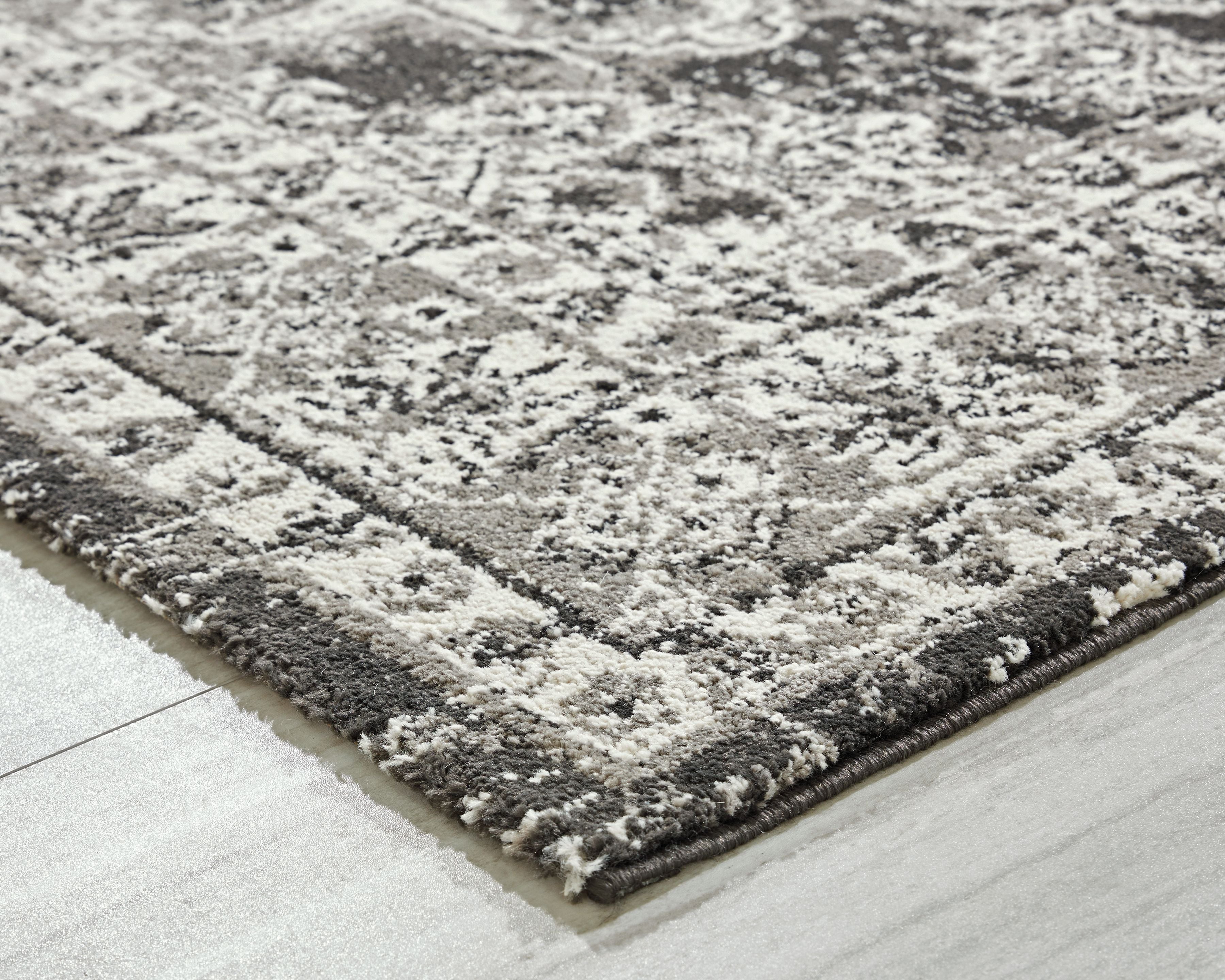 Glennisman rug close-up, mottled gray and black texture with distressed medallion motifs
