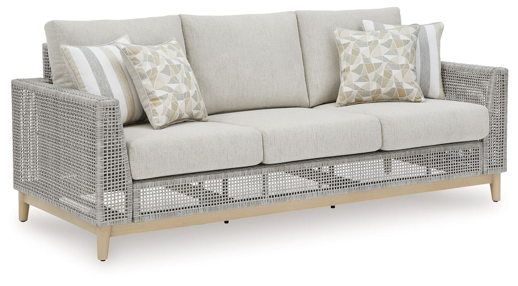 Gray woven outdoor loveseat with seat cushions and two patterned throw pillows