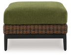 Brown wicker ottoman with green cushion and dark legs