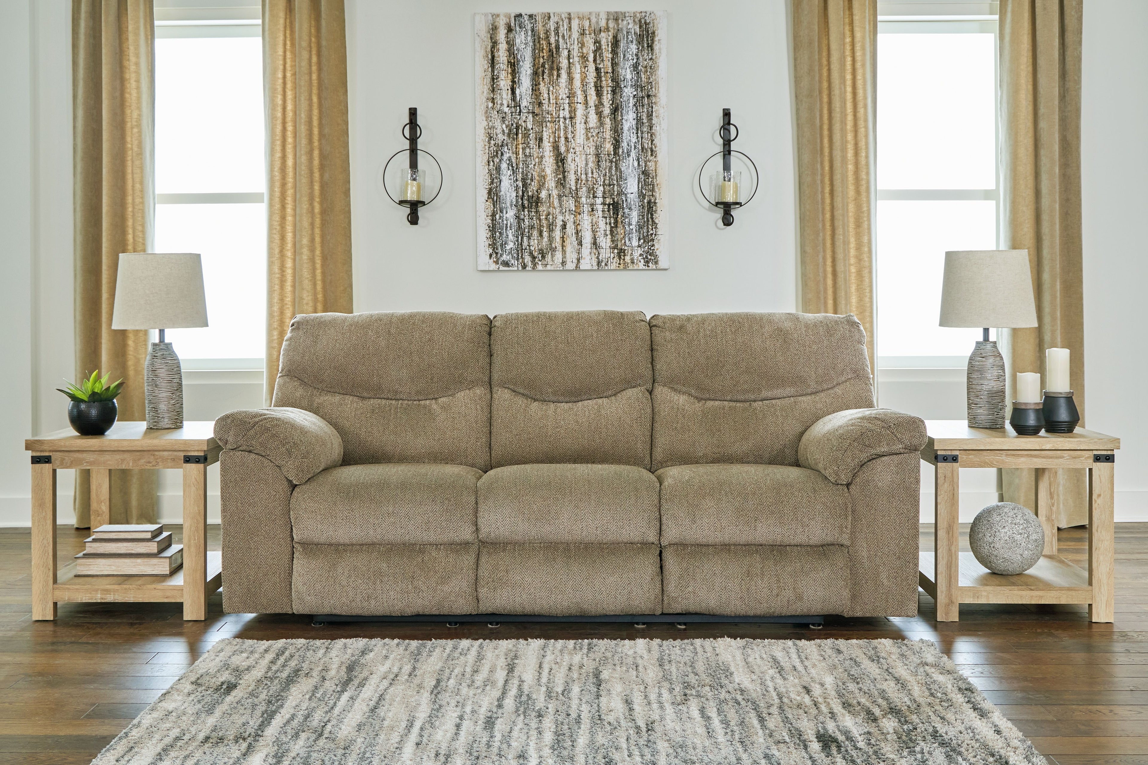 Reclining sofa in beige fabric with three seat sections and rolled armrests, styled in a room.