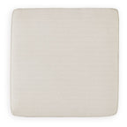 Square ottoman seat upholstered in beige fabric with rounded corners.