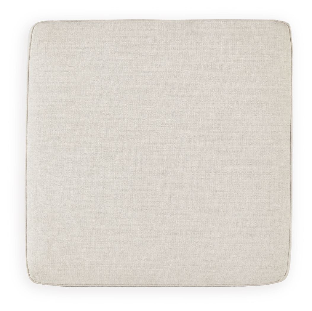 Square ottoman seat upholstered in beige fabric with rounded corners.
