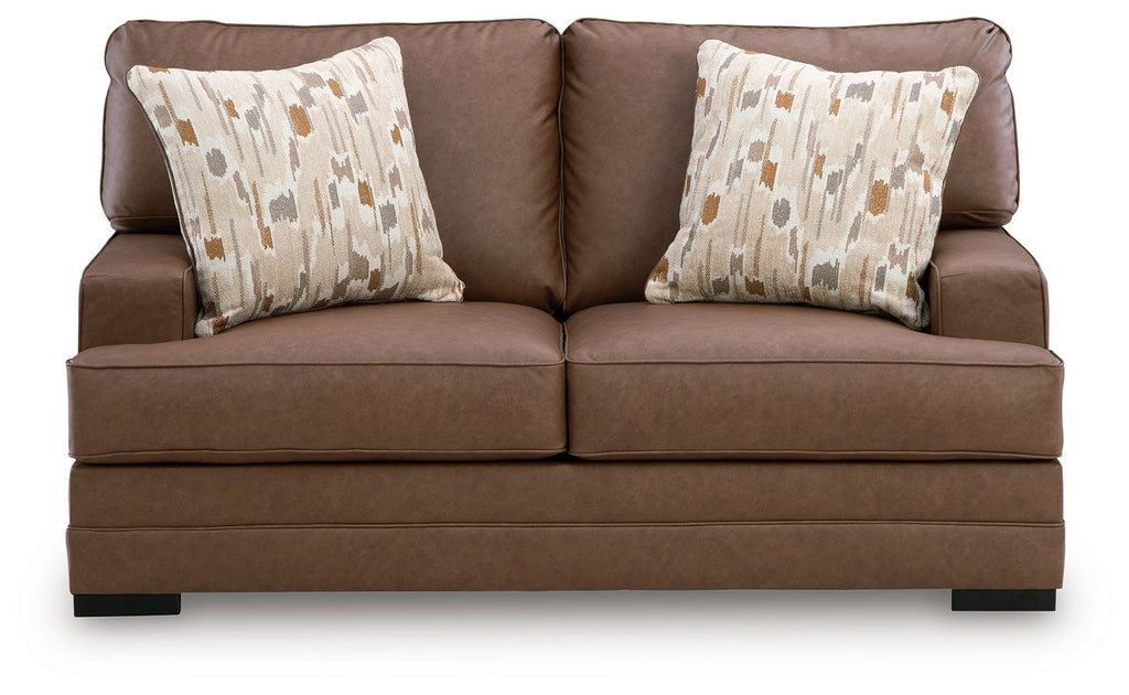 Caramel-brown loveseat with two patterned throw pillows and low profile