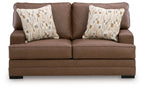 Caramel-brown loveseat with two patterned throw pillows and low profile