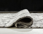 Glennisman rug corner close-up, short pile with gray top and dark underside, folded edge