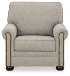 Light beige upholstered armchair with rounded arms and beaded nailhead trim