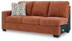 Brown fabric sofa with seat cushions and teal patterned throw pillow