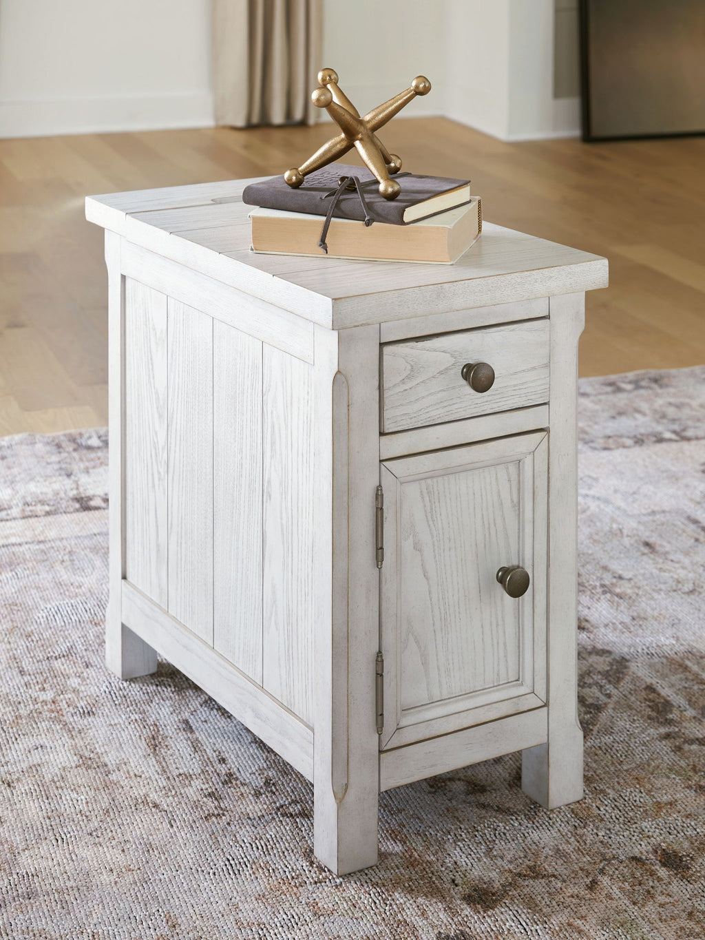 White side table with paneled cabinet doors and a drawer, distressed wood finish.