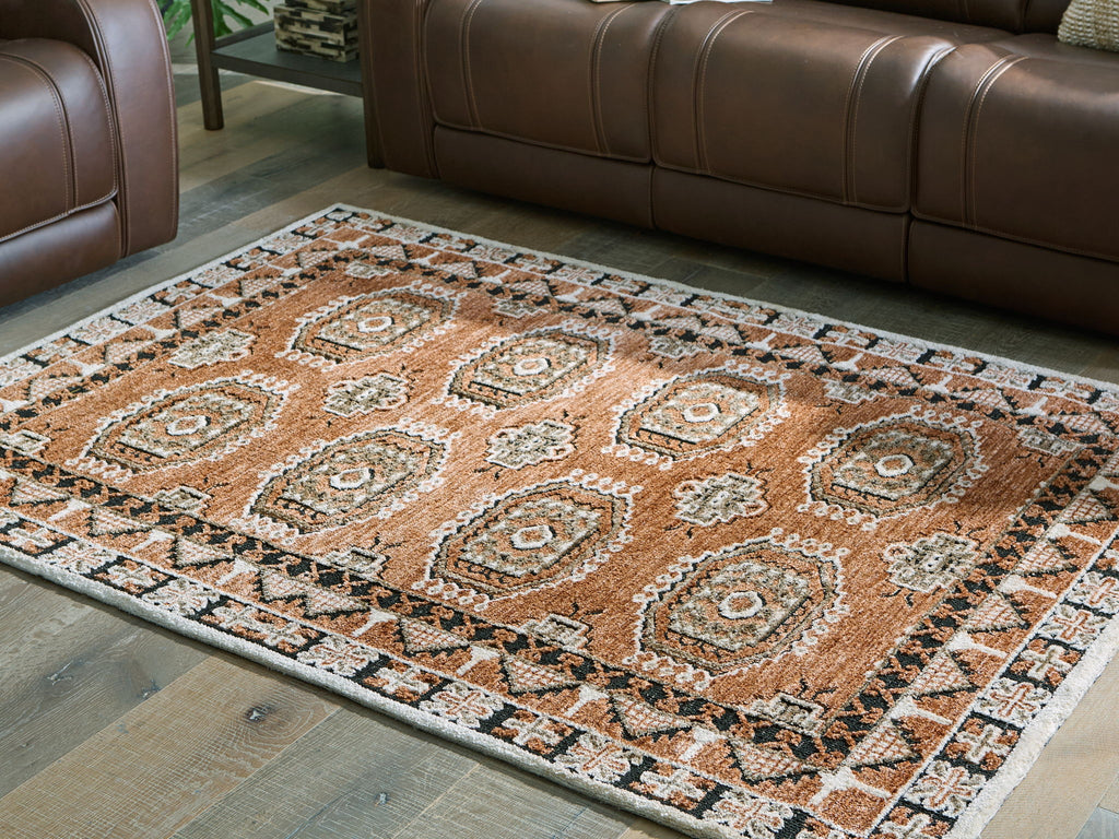Rectangular brown area rug with repeating medallions and ornate border, flat weave.