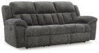 Reclining sofa in dark gray fabric with padded headrest and smooth reclining seat