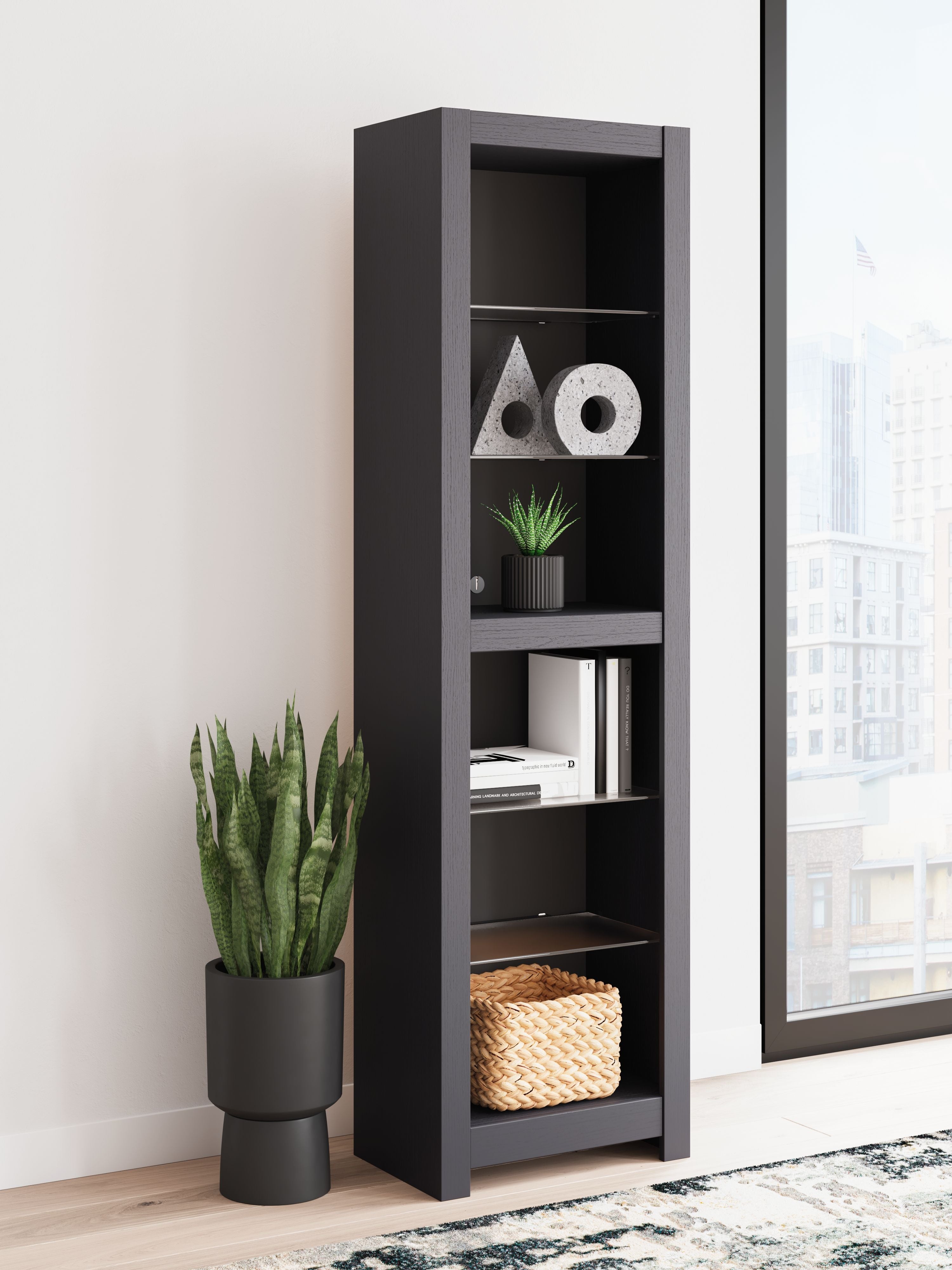 Black tall open bookshelf with several shelves holding decor and baskets