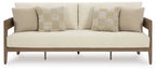 Beige sofa with two patterned square cushions and dark brown wooden legs