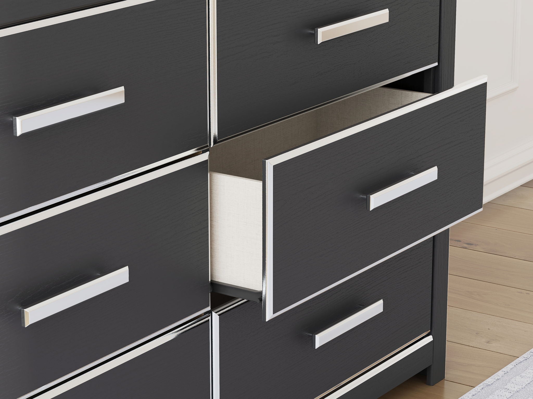 Six-drawer dresser drawer fronts with silver bar pulls and dark drawer surfaces.