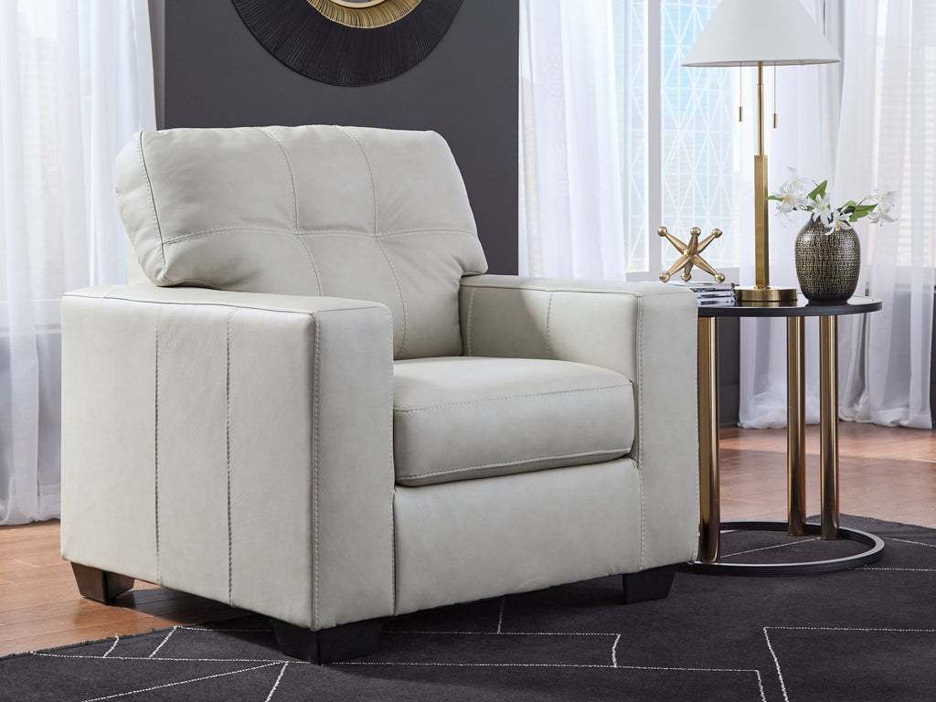 Light beige upholstered accent chair angled view with stitched back and arms