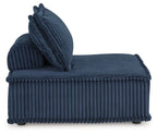 Blue ribbed accent chair with attached back cushion and curled throw pillow