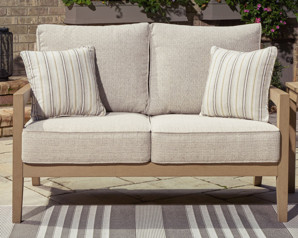 Beige loveseat with two striped throw pillows and two back cushions, driftwood frame