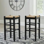 Two tall black stools with woven beige seat pads and slatted side bars