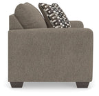 Upholstered chair and a half with dark gray fabric and geometric patterned back pillow