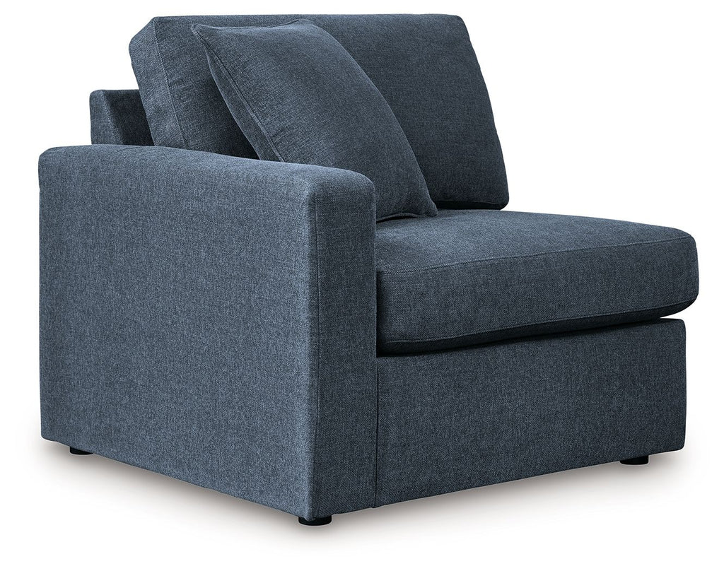 Ink blue fabric corner chair with wide armrests and deep, tufted seat cushions.