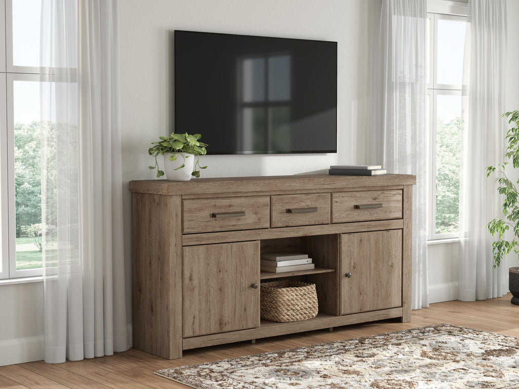 Light brown wood TV stand with drawers and open shelf area under mounted TV.
