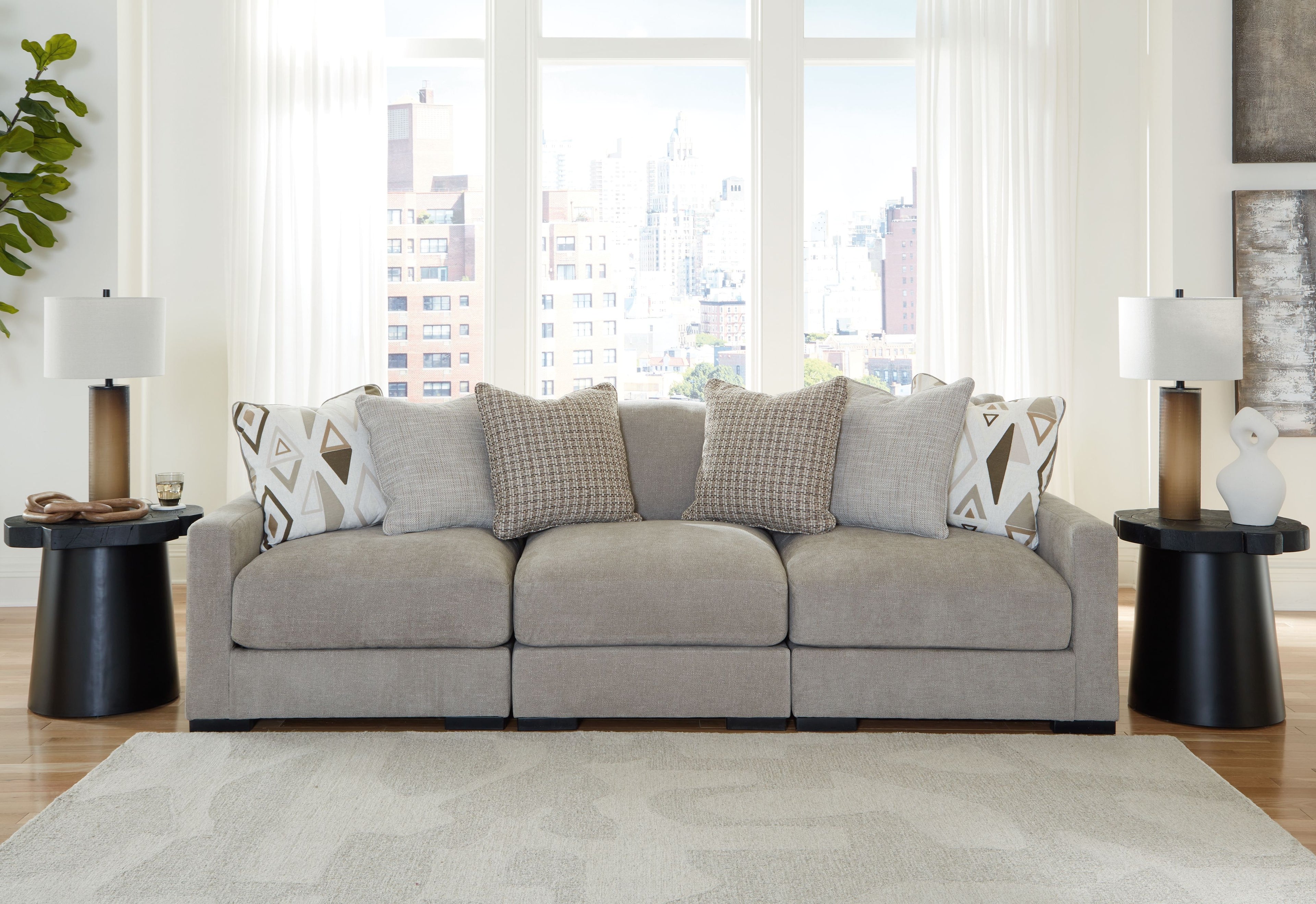 Light gray 3-seat sofa sectional with textured pillows and geometric accent cushions