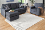 Light gray area rug with large curved arch design and textured low pile