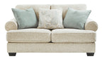 Sandstone loveseat front view with two teal pillows and a light patterned throw pillow