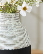 Close-up of black and white ceramic vase with textured horizontal stripes