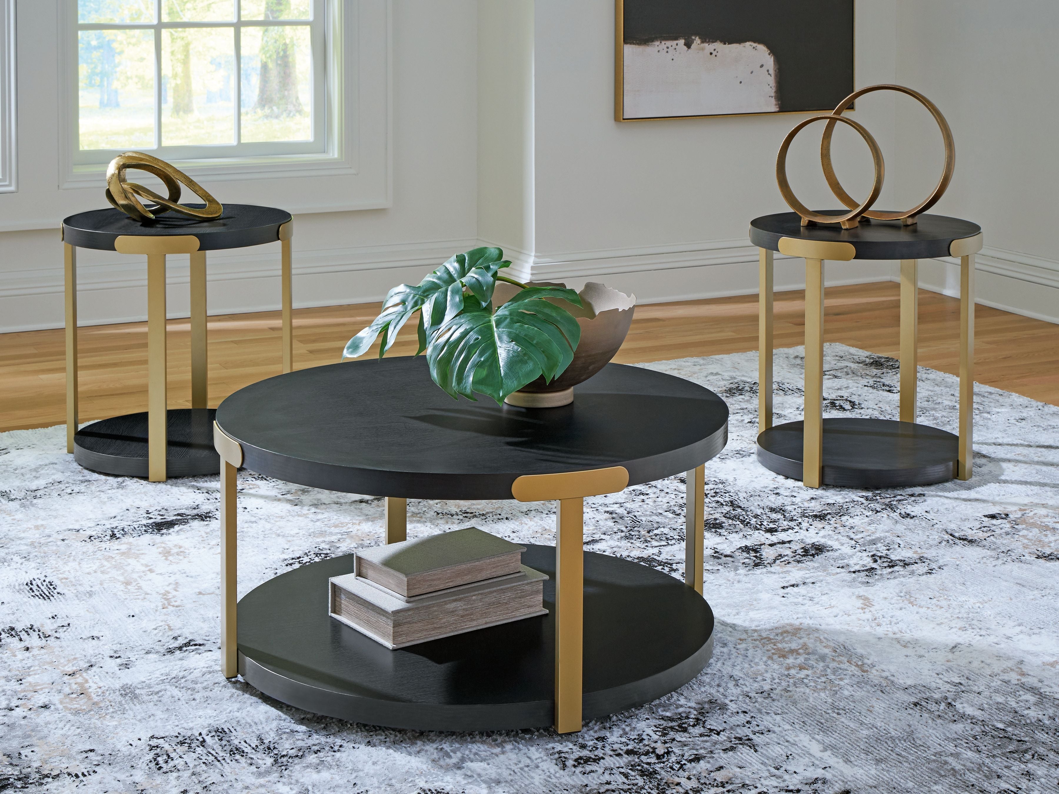 Three round nesting side tables with black tops and brass-finish legs