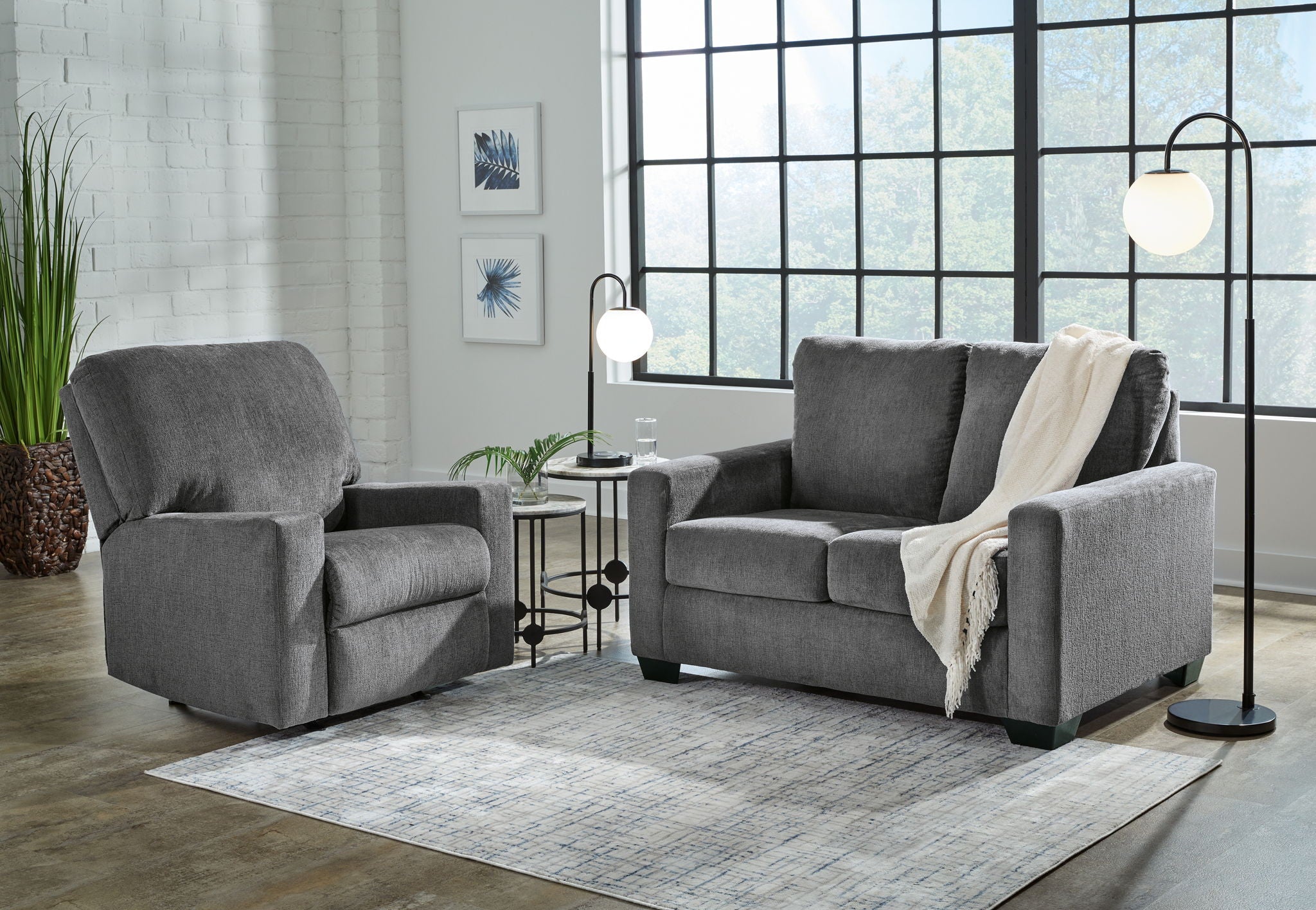 Dark gray fabric sofa with matching armchair, throw draped on sofa back