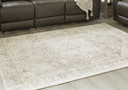 Beige area rug with faded ornate pattern, laid flat