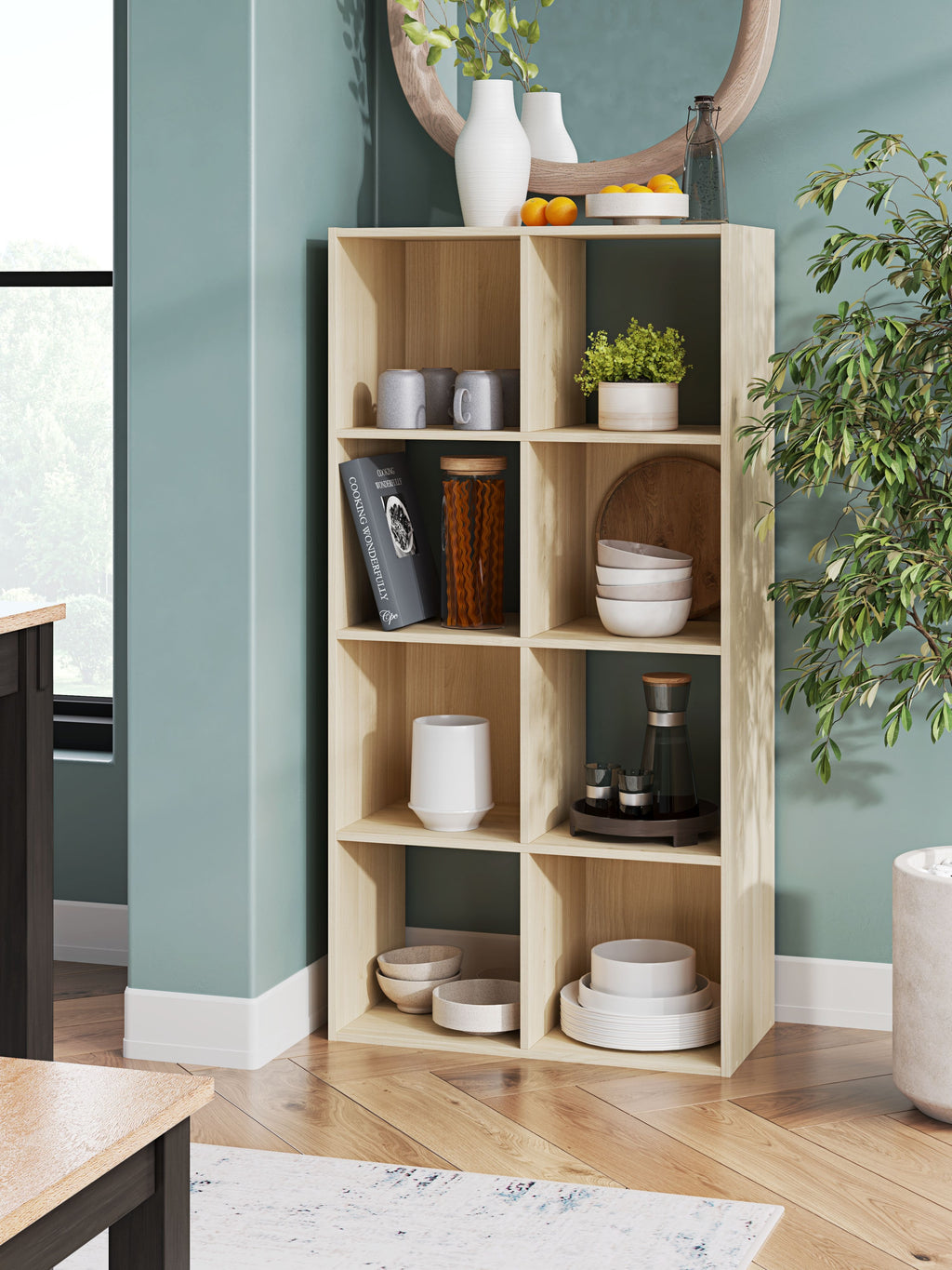 Light wood cube organizer with open shelves displaying jars, cups, and tabletop items