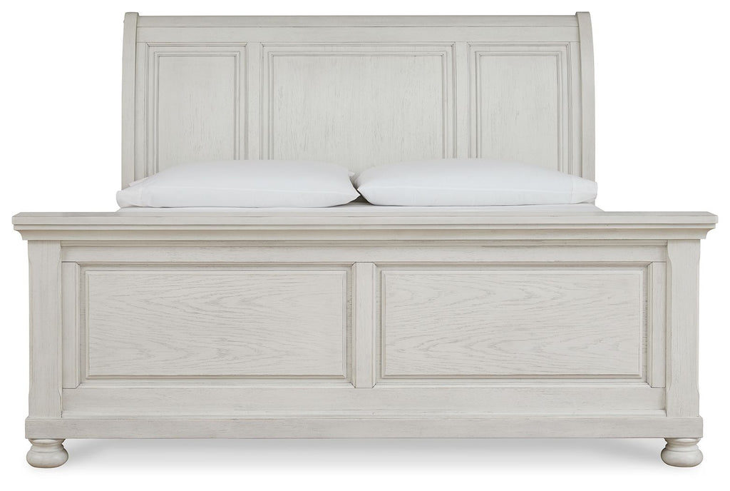 White sleigh bed with paneled headboard, matching footboard, and turned feet.