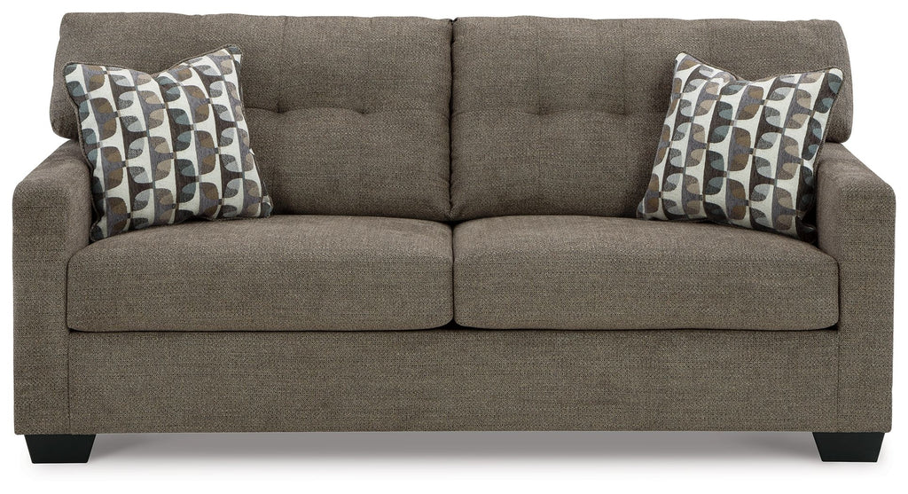 Chocolate sofa sleeper with two patterned throw pillows and tufted back cushions