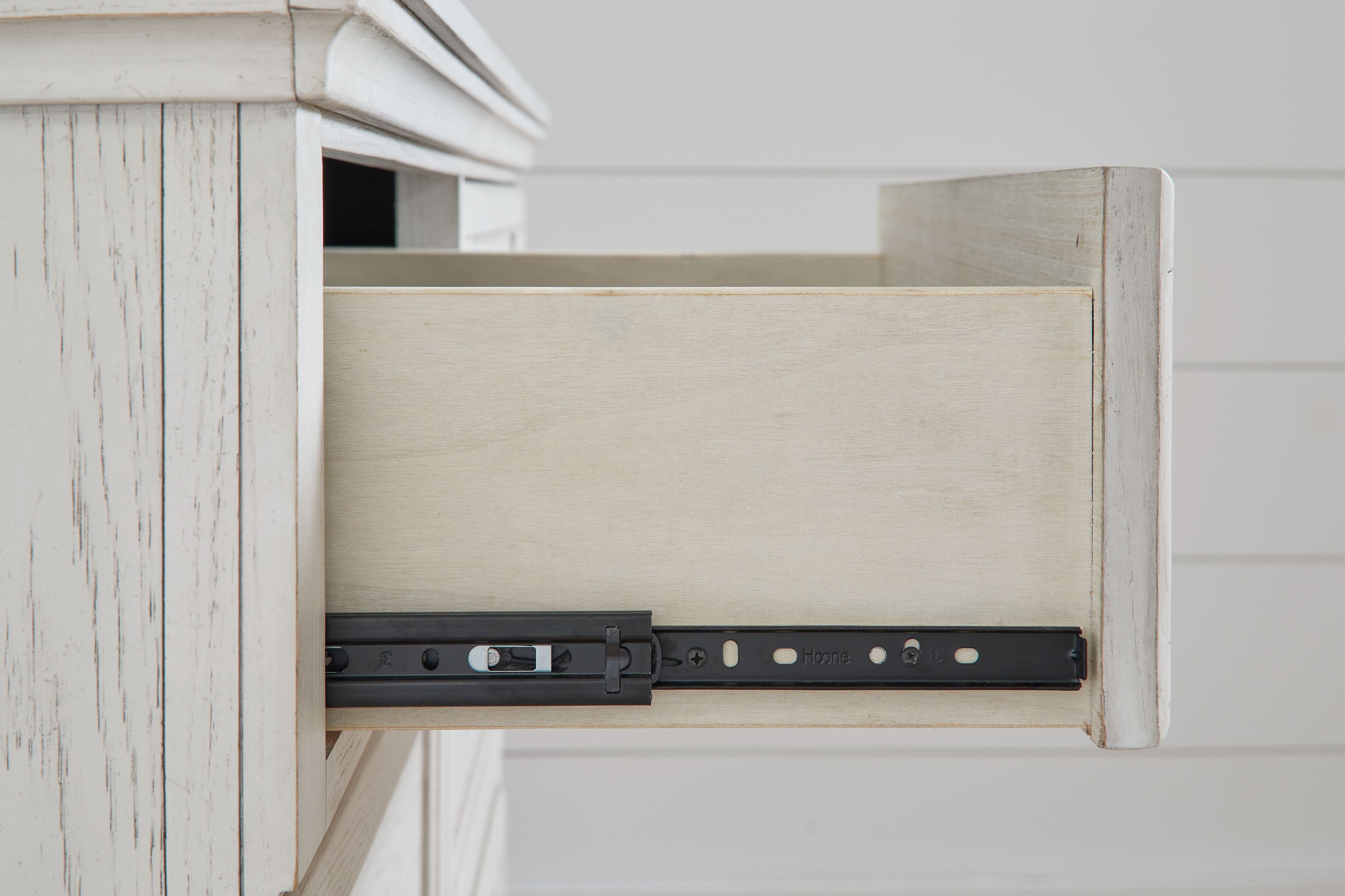 Antique white dresser open drawer showing black hardware track and metal brackets