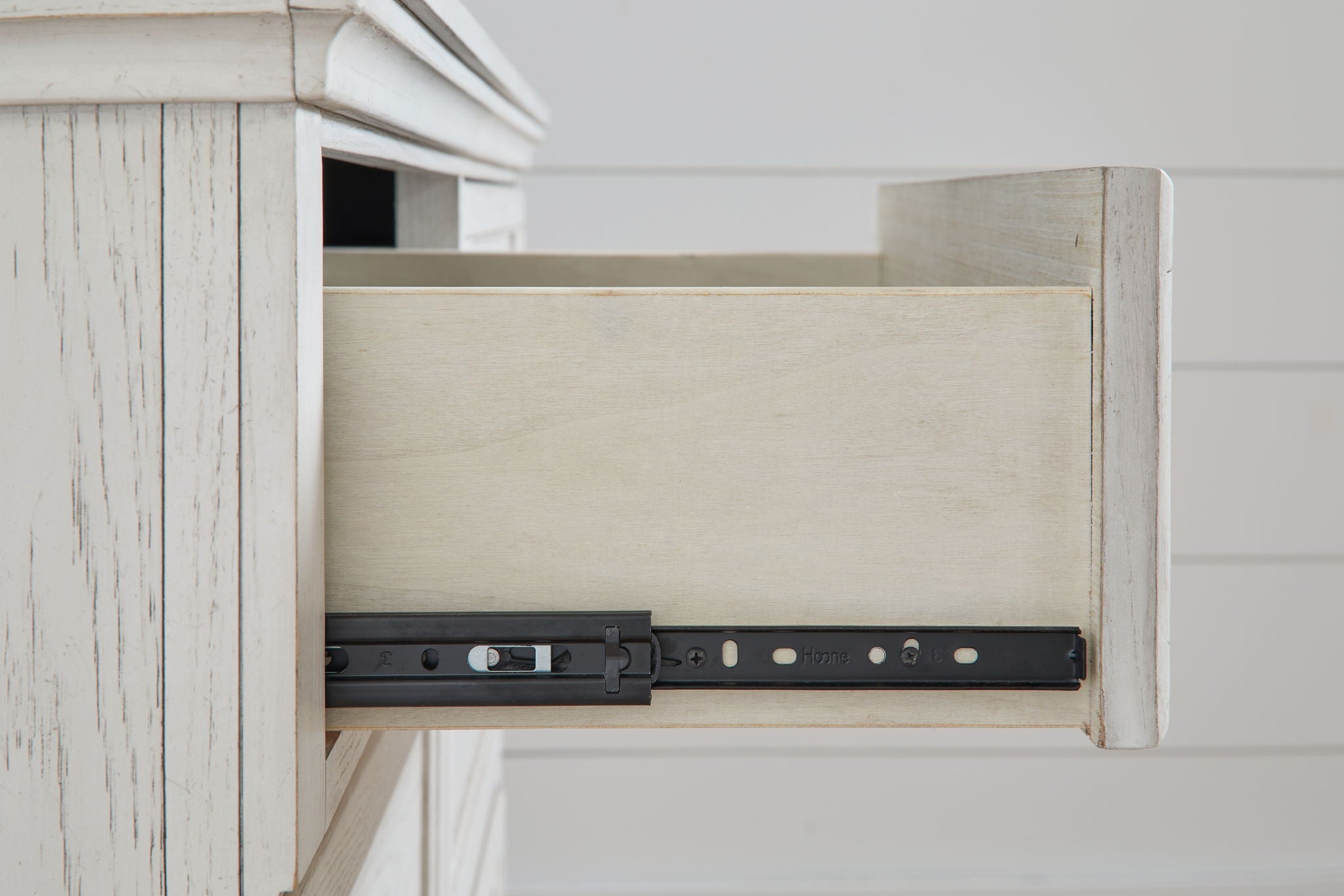 Antique white dresser drawer interior with metal support rail