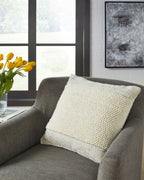 Textured cream throw pillow with stitched edge on sofa