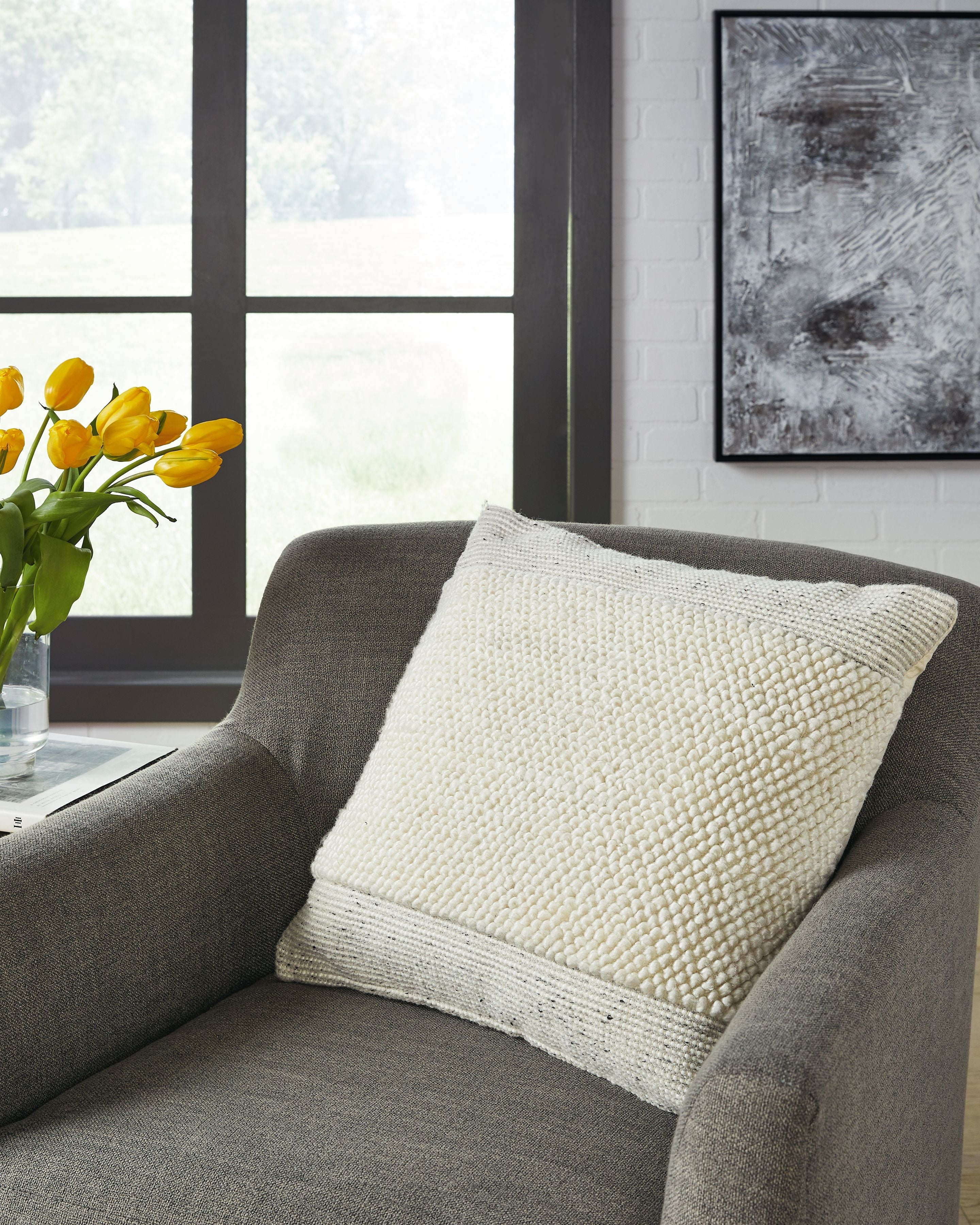Textured cream throw pillow with stitched edge on sofa
