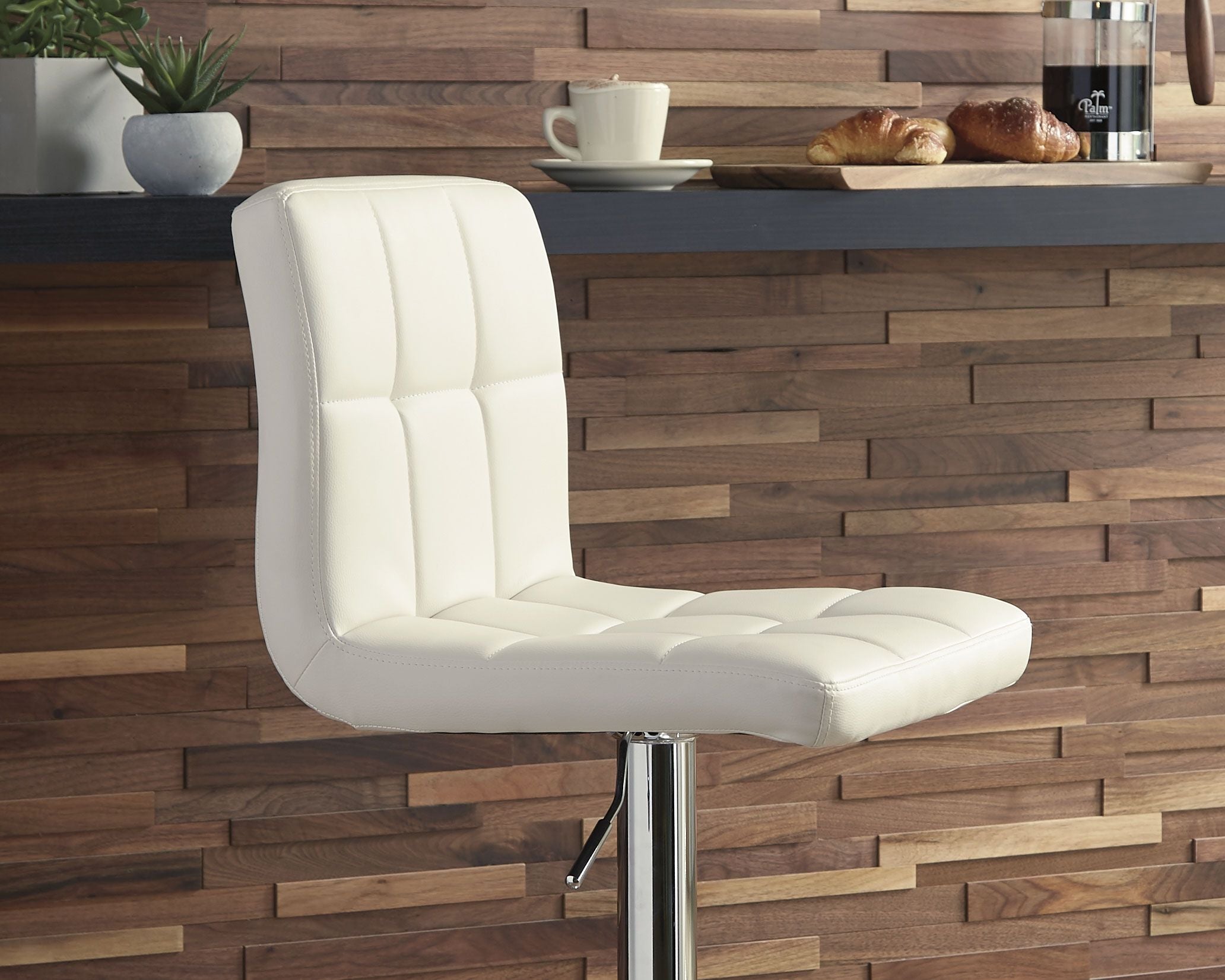 Beige adjustable barstool with padded seat and tall back, chrome base and footrest