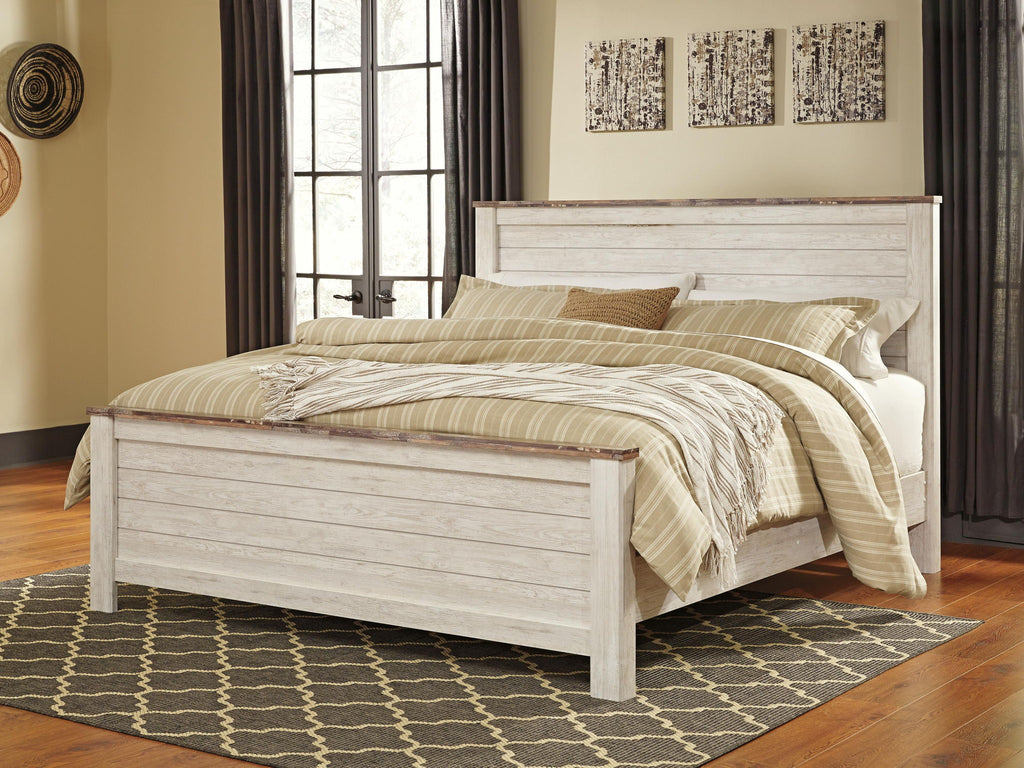 Beige panel bed with slatted headboard, layered blankets and pillows on bed