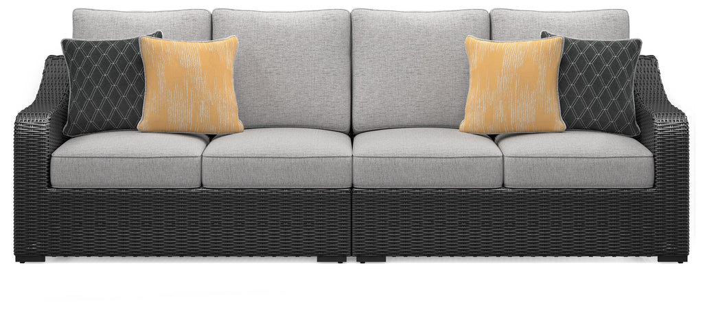 Outdoor loveseat front view with black wicker arms, light gray cushions, yellow and dark pillows