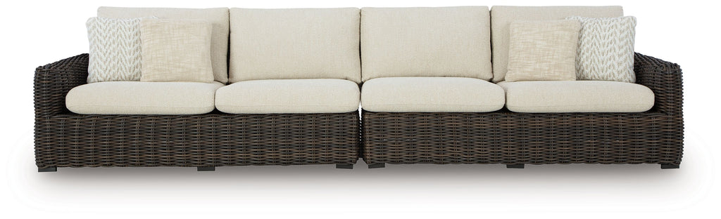 Dark brown wicker loveseat with beige seat, back, and patterned accent cushions