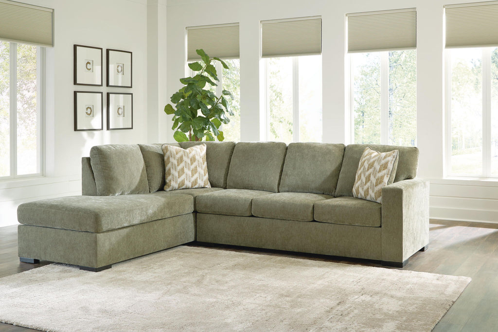 Moss green sectional sofa with corner chaise and patterned throw pillows