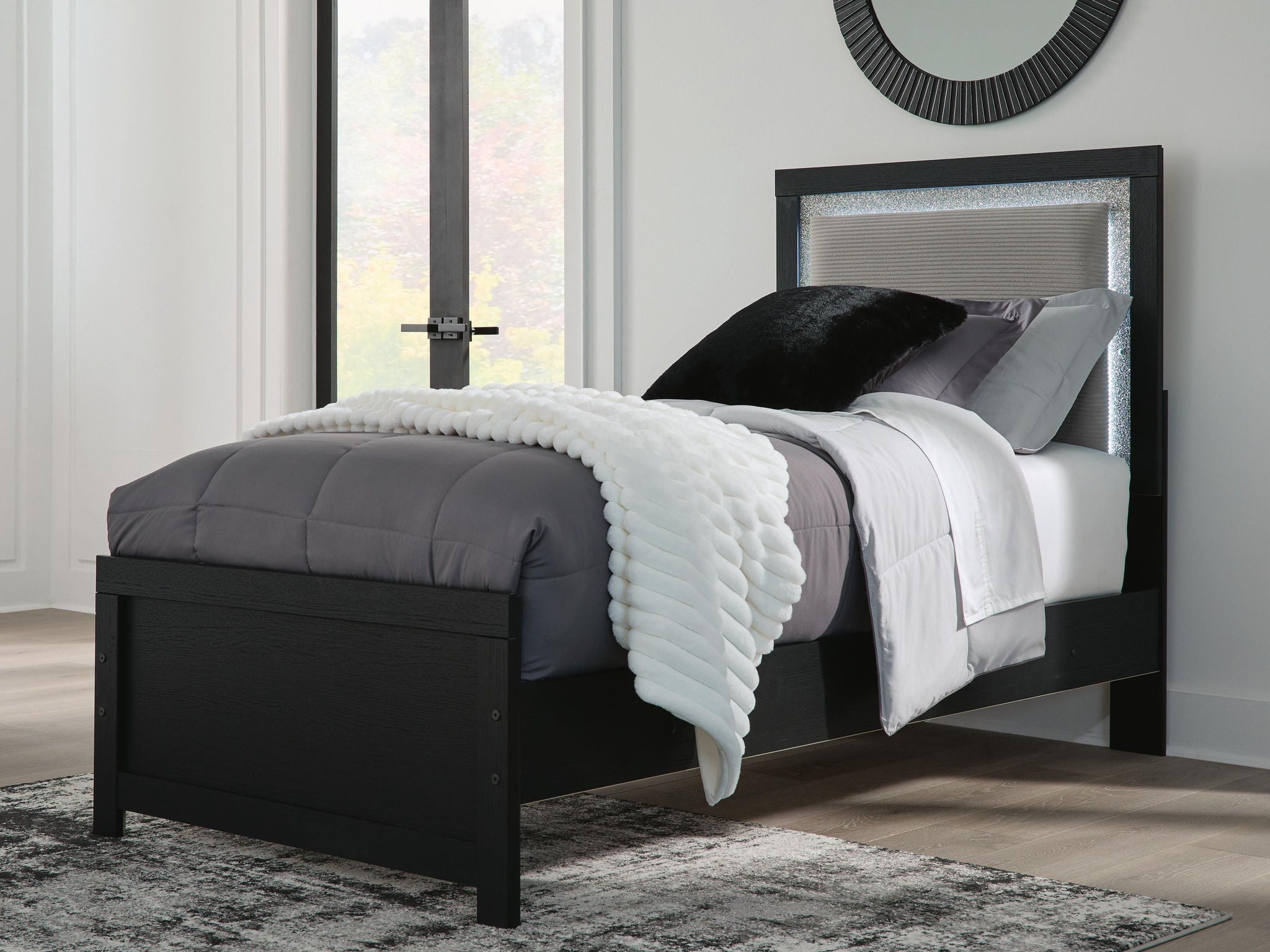 Black upholstered panel bed with tall headboard and padded side rails