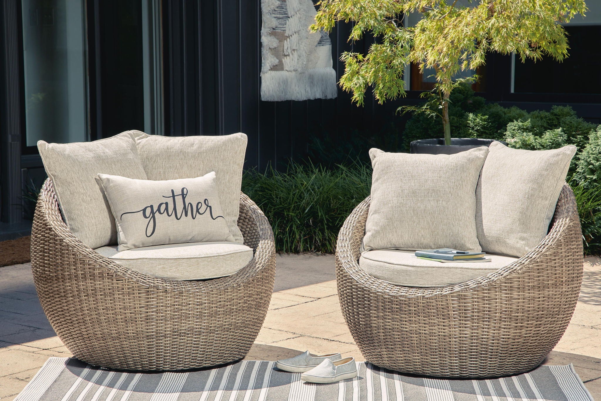 Beige woven swivel lounge chairs with seat cushion, back pillows, and 'gather' throw pillow