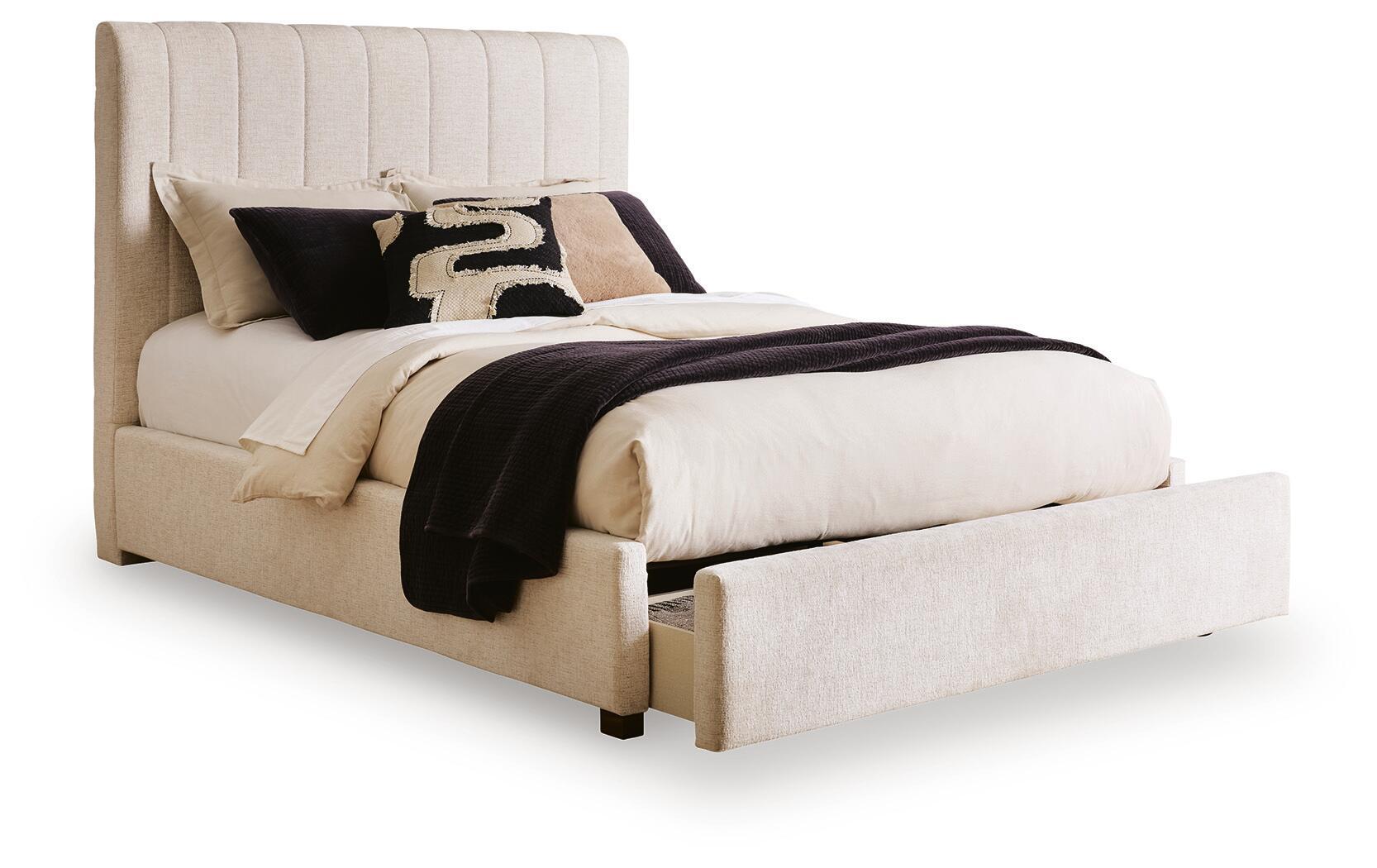 Beige upholstered queen bed with low padded footboard and black-and-beige accent pillows