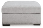 Light gray upholstered storage ottoman with hinged lid and dark feet