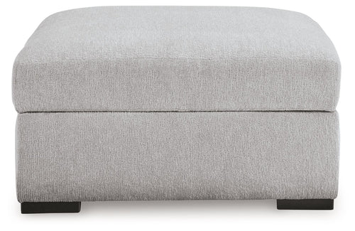 Light gray upholstered storage ottoman with hinged lid and dark feet